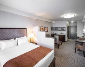 Day use studio suite with living area, workspace and in-room kitchen at Acclaim Hotel Calgary Airport.