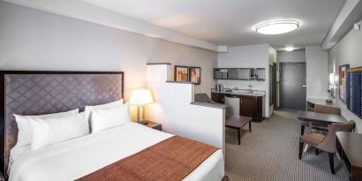 Day use studio suite with living area, workspace and in-room kitchen at Acclaim Hotel Calgary Airport.