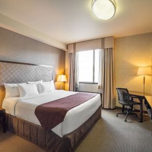 Standard day use room with TV, work desk and private bathroom at Acclaim Hotel Calgary Airport.