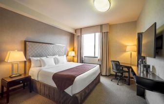 Standard day use room with TV, work desk and private bathroom at Acclaim Hotel Calgary Airport.