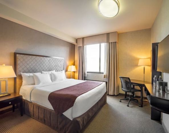 Standard day use room with TV, work desk and private bathroom at Acclaim Hotel Calgary Airport.