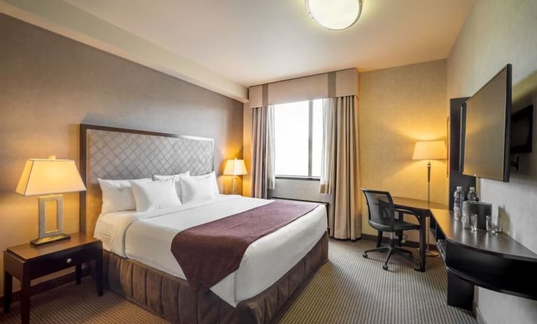 Standard day use room with TV, work desk and private bathroom at Acclaim Hotel Calgary Airport.