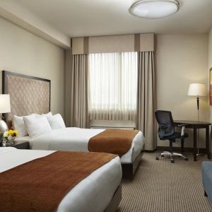 Day use twin room with TV and work desk at Acclaim Hotel Calgary Airport.