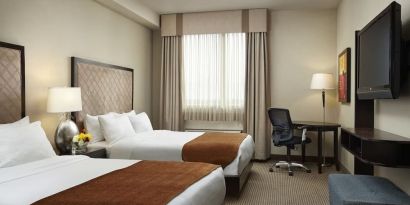 Day use twin room with TV and work desk at Acclaim Hotel Calgary Airport.