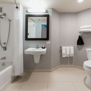 Guest bathroom with shower and tub at Courtyard By Marriott Los Angeles LAX/Century Boulevard.