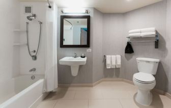 Guest bathroom with shower and tub at Courtyard By Marriott Los Angeles LAX/Century Boulevard.