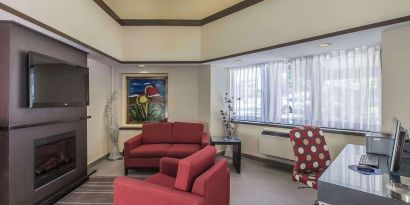 Hotel lobby with fireplace and worskpace with computer and printer at Comfort Inn Corner Brook.