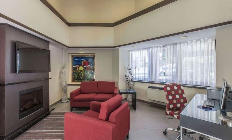 Hotel lobby with fireplace and worskpace with computer and printer at Comfort Inn Corner Brook.