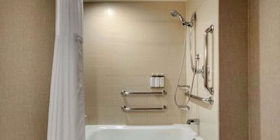 Guest bathroom with shower and tub at Cambria Suites Denver Airport.