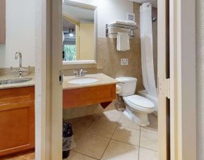 Guest bathroom with shower and tub at Rodeway Inn & Suites Fort Lauderdale Airport & Cruise Port.