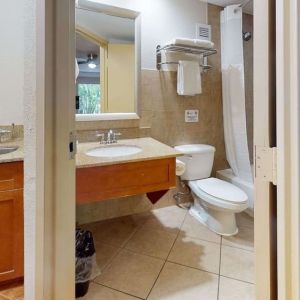 Guest bathroom with shower and tub at Rodeway Inn & Suites Fort Lauderdale Airport & Cruise Port.