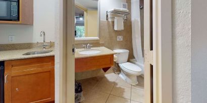 Guest bathroom with shower and tub at Rodeway Inn & Suites Fort Lauderdale Airport & Cruise Port.