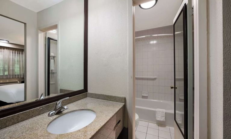 Guest bathroom with shower and tub at Best Western Woodbury Inn.