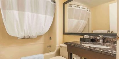 Guest bathroom with tub and free toiletries at Comfort Inn Cobourg.