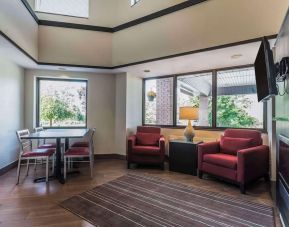 Lobby lounge with TV screen and fireplace at Comfort Inn Cobourg.