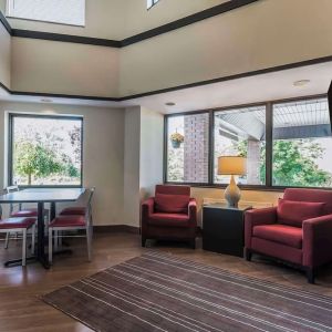 Lobby lounge with TV screen and fireplace at Comfort Inn Cobourg.