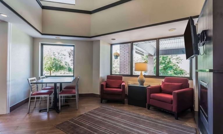 Lobby lounge with TV screen and fireplace at Comfort Inn Cobourg.