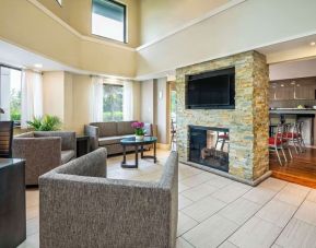 Lobby lounge with TV screen and fireplace at Comfort Inn Newmarket.