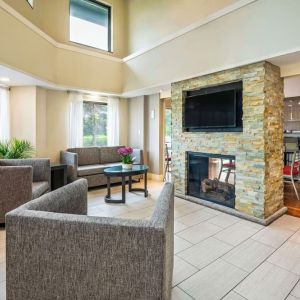 Lobby lounge with TV screen and fireplace at Comfort Inn Newmarket.