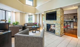 Lobby lounge with TV screen and fireplace at Comfort Inn Newmarket.