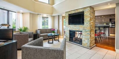 Lobby lounge with TV screen and fireplace at Comfort Inn Newmarket.