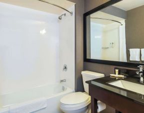 Guesth bathroom with tub and shower at Comfort Inn Kingston HWY 401.
