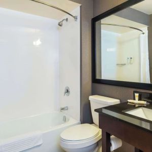 Guesth bathroom with tub and shower at Comfort Inn Kingston HWY 401.
