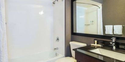 Guesth bathroom with tub and shower at Comfort Inn Kingston HWY 401.
