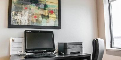 Business center with computer, printer and ergonomic chair at Comfort Inn Laval.