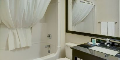 Guest bathroom with tub and free toiletries at Comfort Inn Chicoutimi.