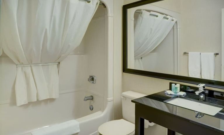 Guest bathroom with tub and free toiletries at Comfort Inn Chicoutimi.