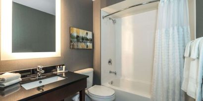 Private guest bathroom with shower and tub at Comfort Inn Dryden.