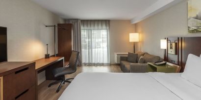 Day use room with TV, work desk and sofa at Comfort Inn Dryden.