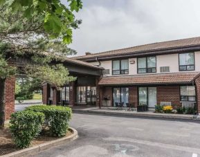 Hotel exterior with lounge area and parking at Comfort Inn Drummondville.