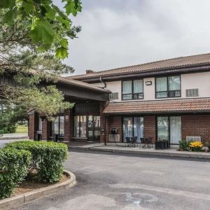 Hotel exterior with lounge area and parking at Comfort Inn Drummondville.