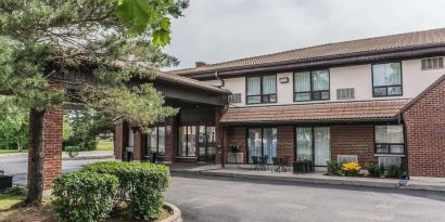 Hotel exterior with lounge area and parking at Comfort Inn Drummondville.