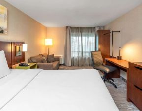 Day use room with work desk and sofa at Comfort Inn Boucherville.