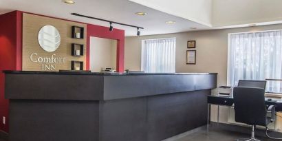 Hotel lobby with business desk with computer, printer and ergonomic chair at Comfort Inn Alma.