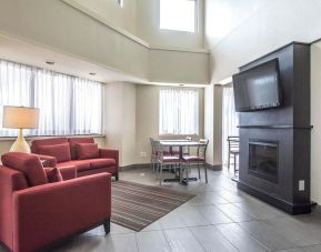 Lobby lounge with comfortable seating, TV screen and fireplace at Comfort Inn Alma.