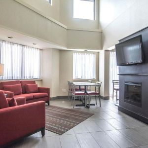 Lobby lounge with comfortable seating, TV screen and fireplace at Comfort Inn Alma.