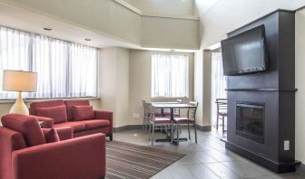 Lobby lounge with comfortable seating, TV screen and fireplace at Comfort Inn Alma.