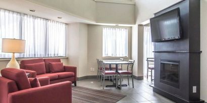 Lobby lounge with comfortable seating, TV screen and fireplace at Comfort Inn Alma.