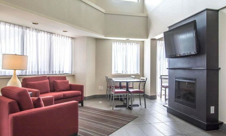 Lobby lounge with comfortable seating, TV screen and fireplace at Comfort Inn Alma.