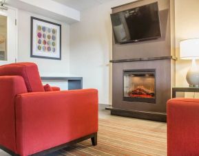 Lobby lounge with TV screen and fireplace at Comfort Inn Brantford.