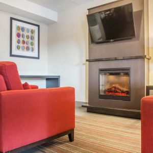 Lobby lounge with TV screen and fireplace at Comfort Inn Brantford.