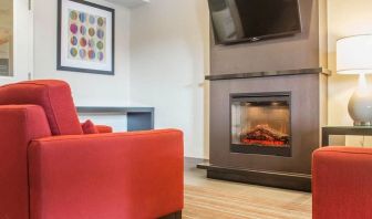 Lobby lounge with TV screen and fireplace at Comfort Inn Brantford.