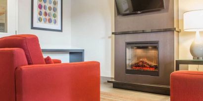 Lobby lounge with TV screen and fireplace at Comfort Inn Brantford.