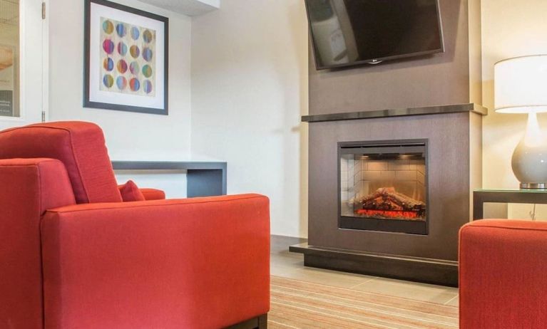 Lobby lounge with TV screen and fireplace at Comfort Inn Brantford.