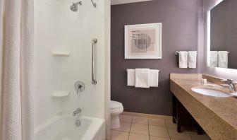 Guest bathroom with combined shower and tub at Courtyard By Marriott Waterloo St. Jacobs.