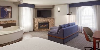 Day use suite with work desk, hot tub and living area with fireplace at Courtyard By Marriott Waterloo St. Jacobs.